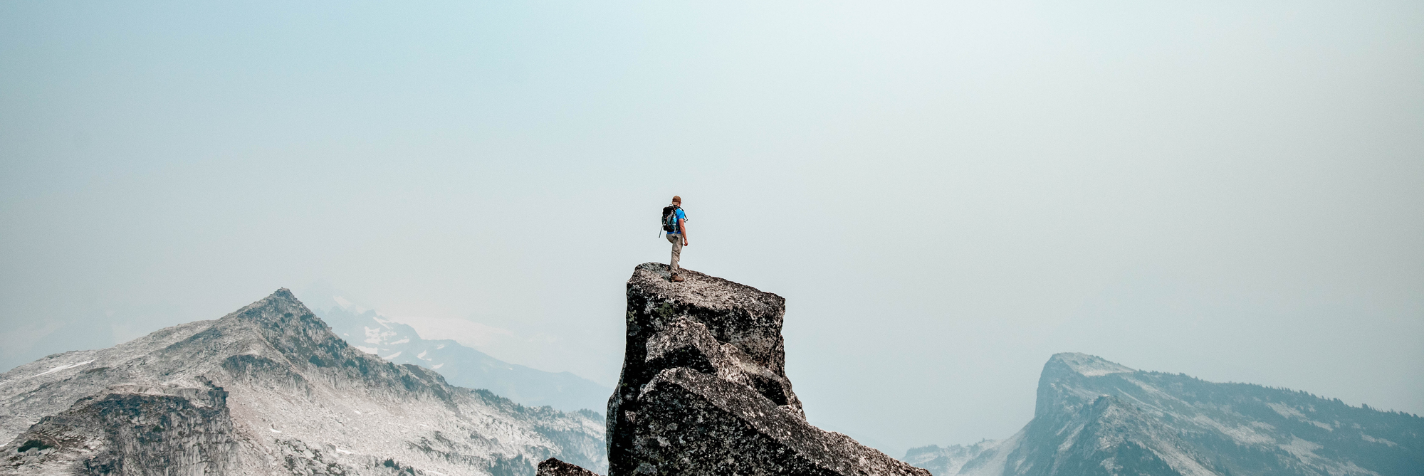 A person on top of a mountain indicating their efforts have been successful